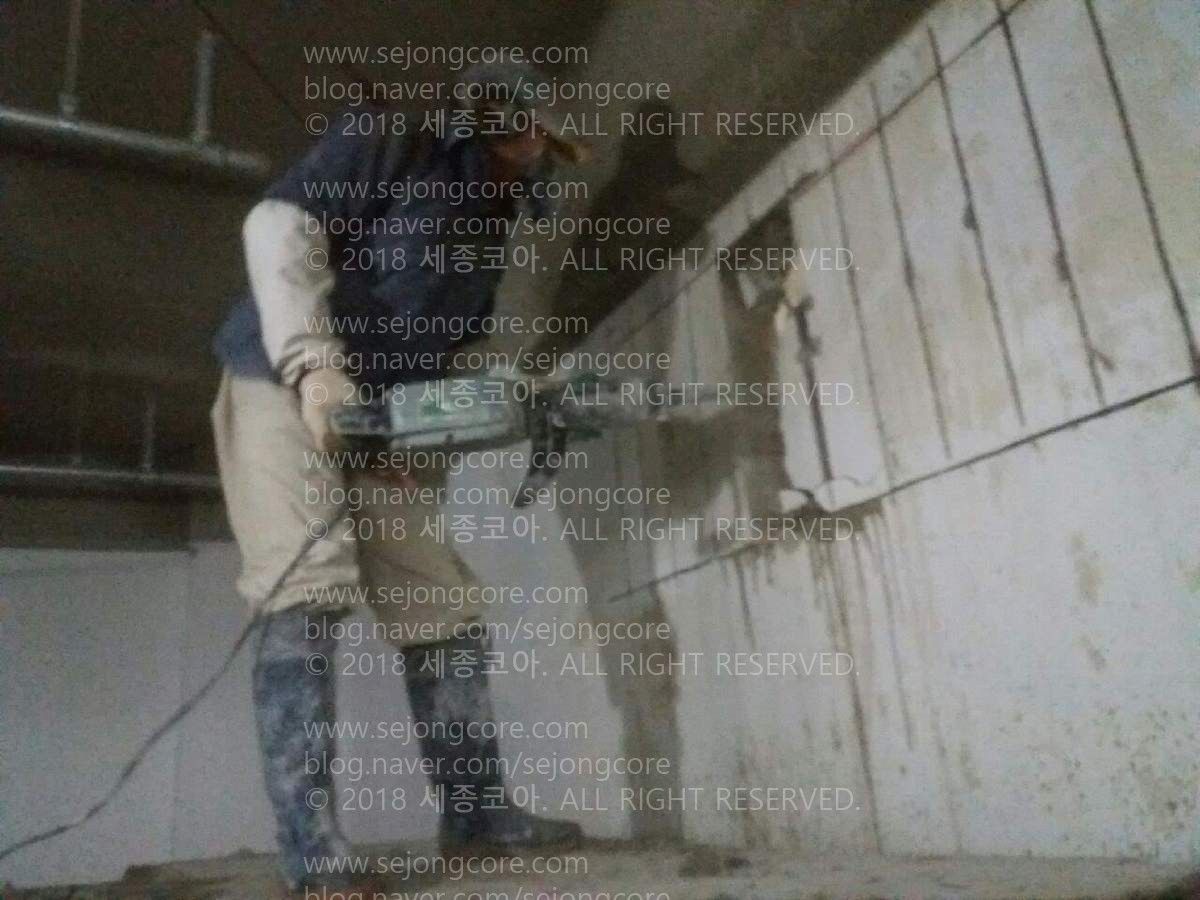 건물 안. 벽을 선을 따라서 컷팅한 뒤에, 그 부분을 프릭커 드릴로 육공 작업하는 모습.
