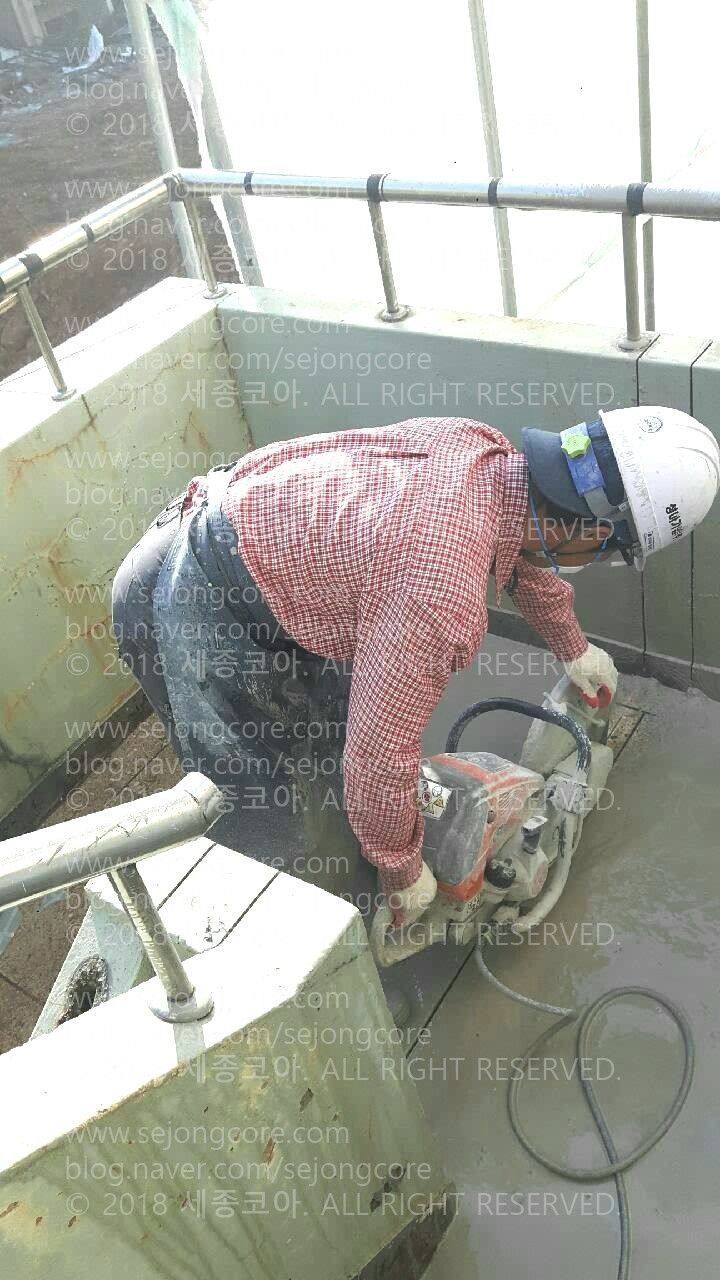 밖이 보이는 계단 위에서 바닥 중간 쯤을 반듯하게 컷팅하는 모습.